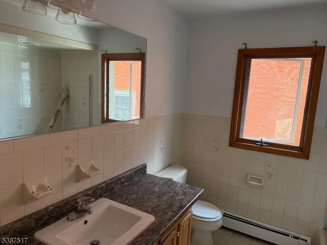 a bathroom with a sink a toilet and a window