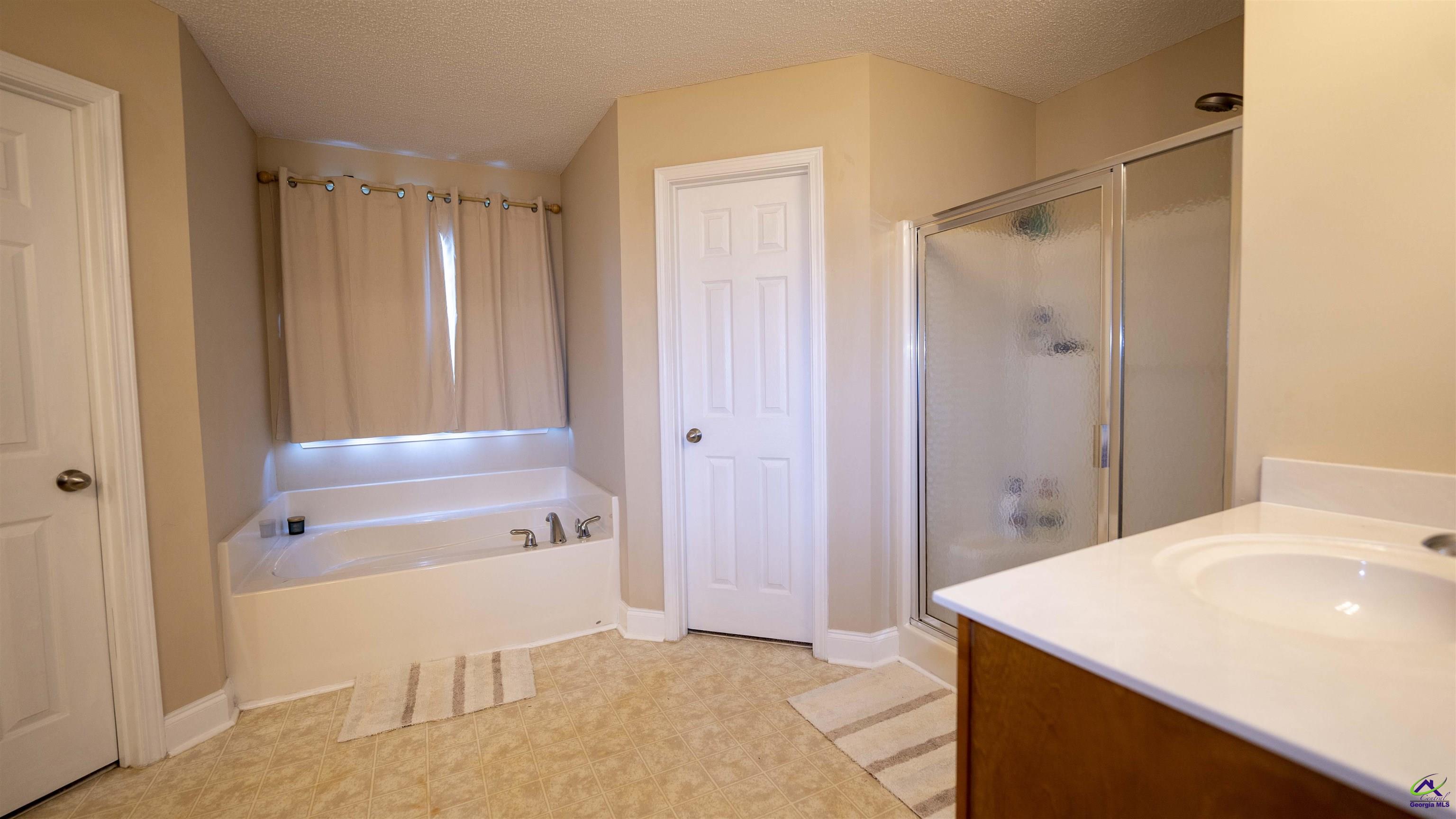 311 Sugarloaf Parkway Perry, GA 31069 - Photo 17 of 31 a bathroom with a shower a sink and a mirror