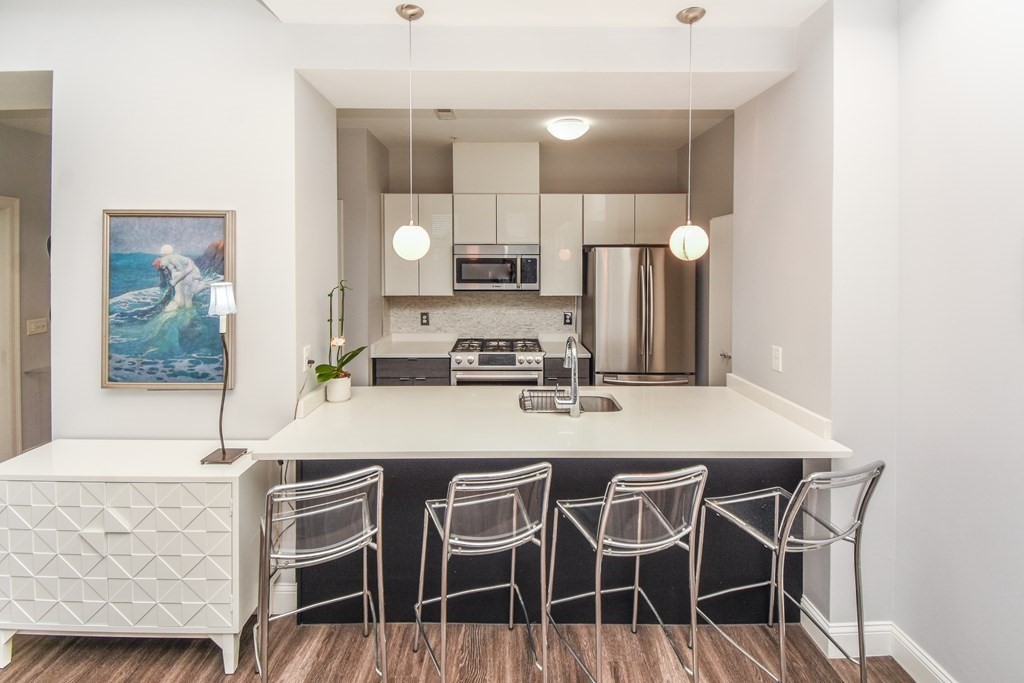 a kitchen with a dining table chairs cabinets and stainless steel appliances