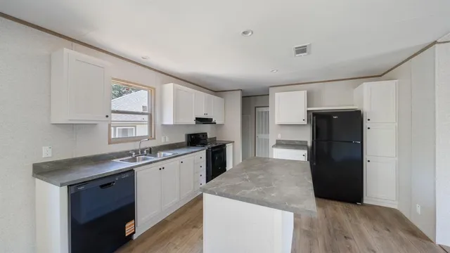 a kitchen with a sink a refrigerator and cabinets