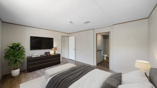 a bedroom with a bed and a flat screen tv