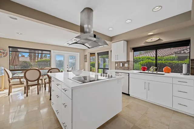 a kitchen with granite countertop sink stove and white cabinets