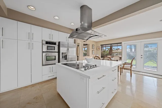 a very nice looking dining room with kitchen island furniture a large window and a rug