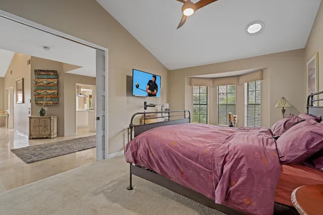 a bedroom with a bed and a large mirror on the dresser