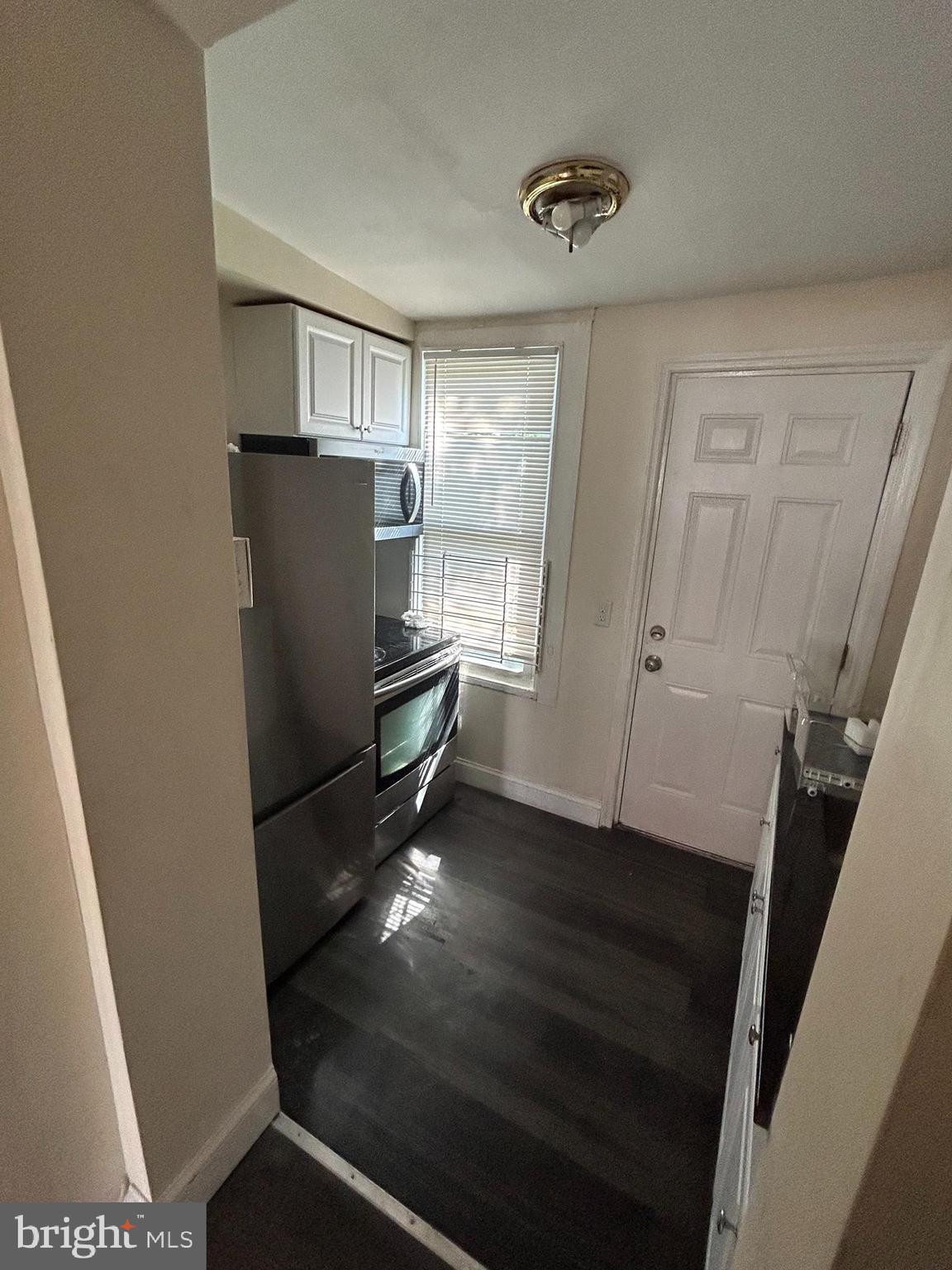 5622 Appletree Street Philadelphia, PA 19139 - Photo 5 of 10 a view of kitchen with refrigerator stove and wooden floor