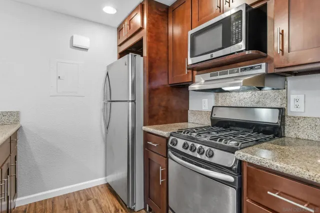 a kitchen with granite countertop cabinets stainless steel appliances and a counter space