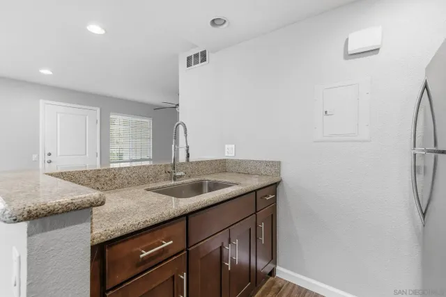 a kitchen with stainless steel appliances granite countertop a sink and a refrigerator
