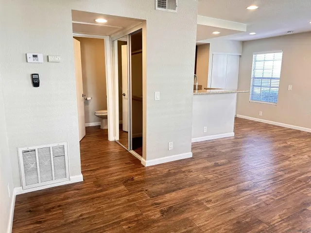a view of a hallway with wooden floor and a living room