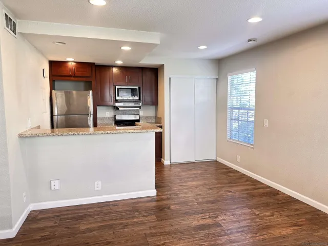 a view of kitchen with kitchen island wooden floor and living room