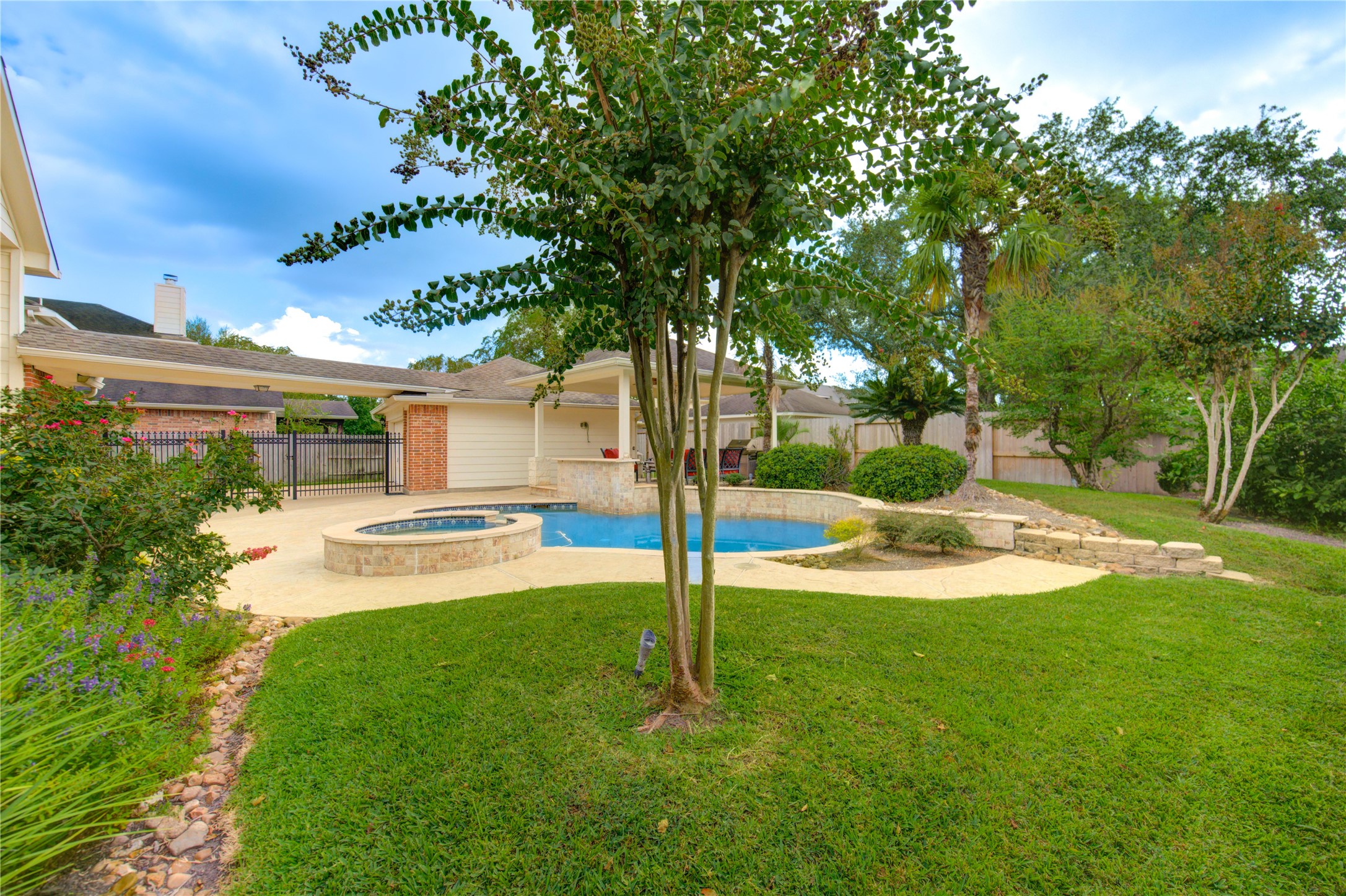 7207 Fiesta Flower Katy, TX 77494 - Photo 27 of 37 Step into a private backyard oasis surrounded by lush, mature landscaping that enhances both beauty and privacy. Tropical plants, flowering shrubs, and mature trees create a serene, resort-like atmosphere, perfectly complementing the sparkling pool, spa, and cabana.