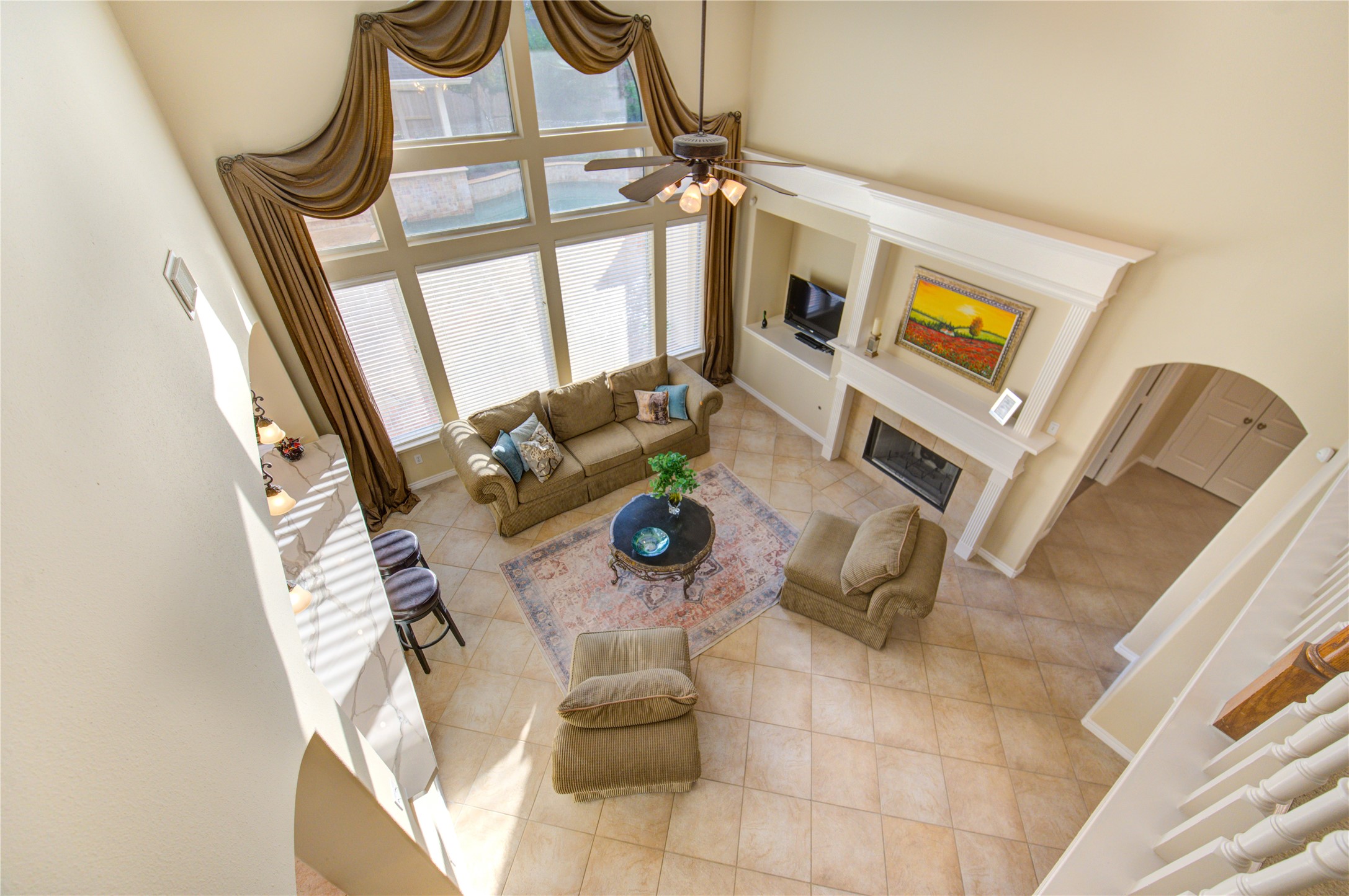7207 Fiesta Flower Katy, TX 77494 - Photo 4 of 37 The spacious living room boasts soaring ceilings and a wall of floor-to-ceiling windows, creating a dramatic backdrop filled with natural light and stunning views of the backyard.