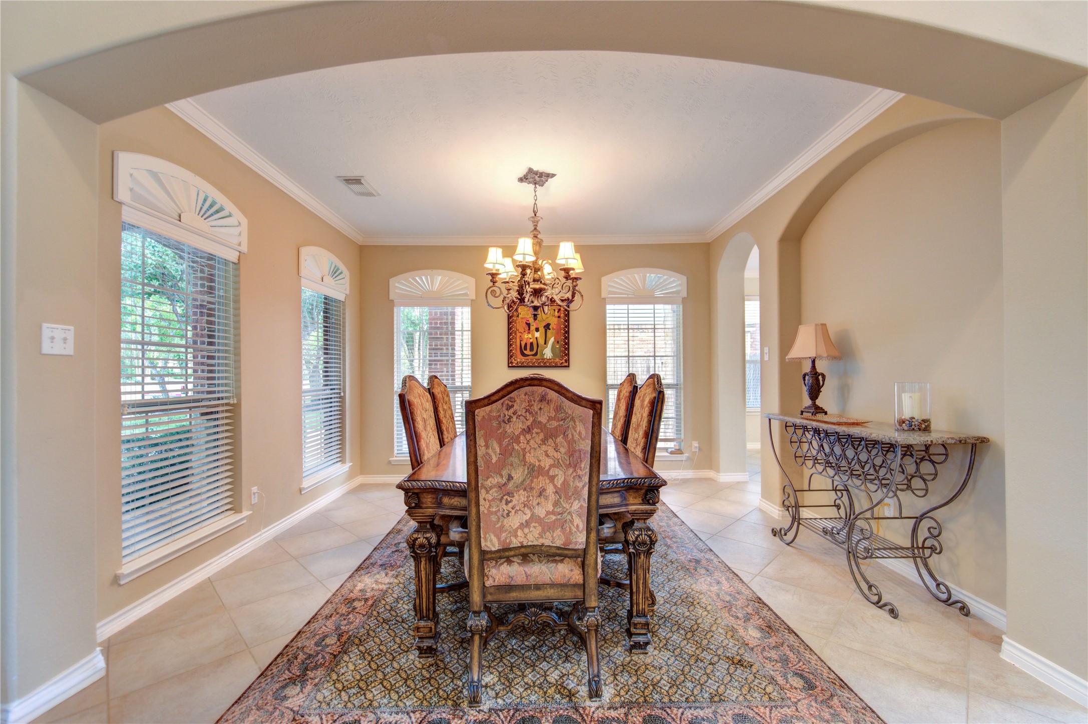 7207 Fiesta Flower Katy, TX 77494 - Photo 6 of 37 Light-filled dining room with easy-to-maintain tile floors that flow continuously from the main living spaces. Plantation shutters and a custom mirror wall add both elegance and a sense of spaciousness, making it ideal for formal dinners or casual family meals.