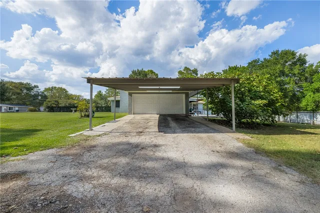 a view of a house with backyard and sitting area