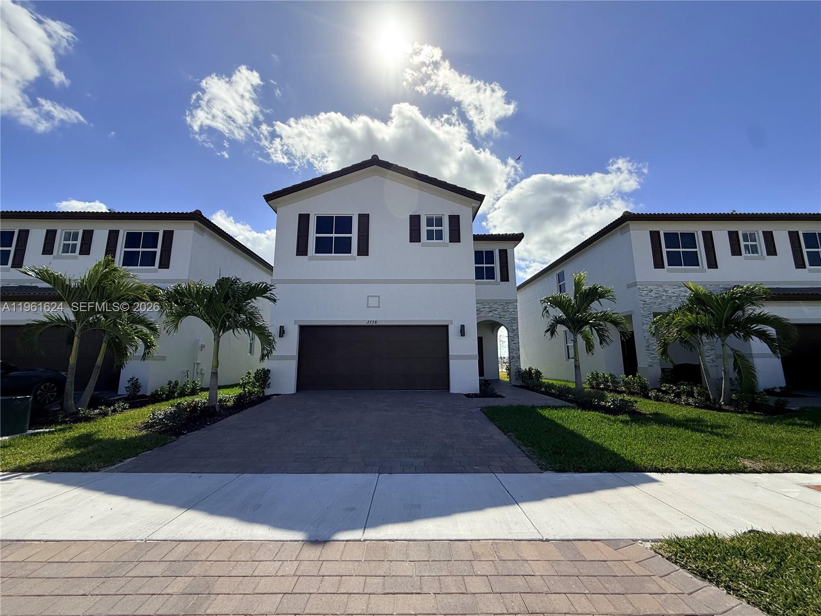 a front view of a house with a yard and a garage