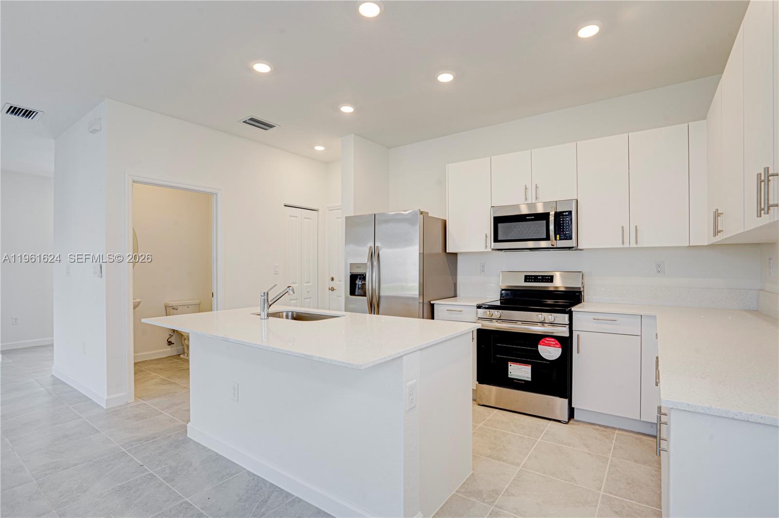 2728 Southeast 24th Court Homestead, FL 33035 - Photo 3 of 18 a kitchen that has a sink and a stove in it