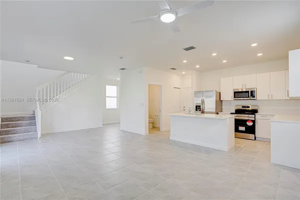 a view of kitchen with stainless steel appliances refrigerator stove microwave and cabinets