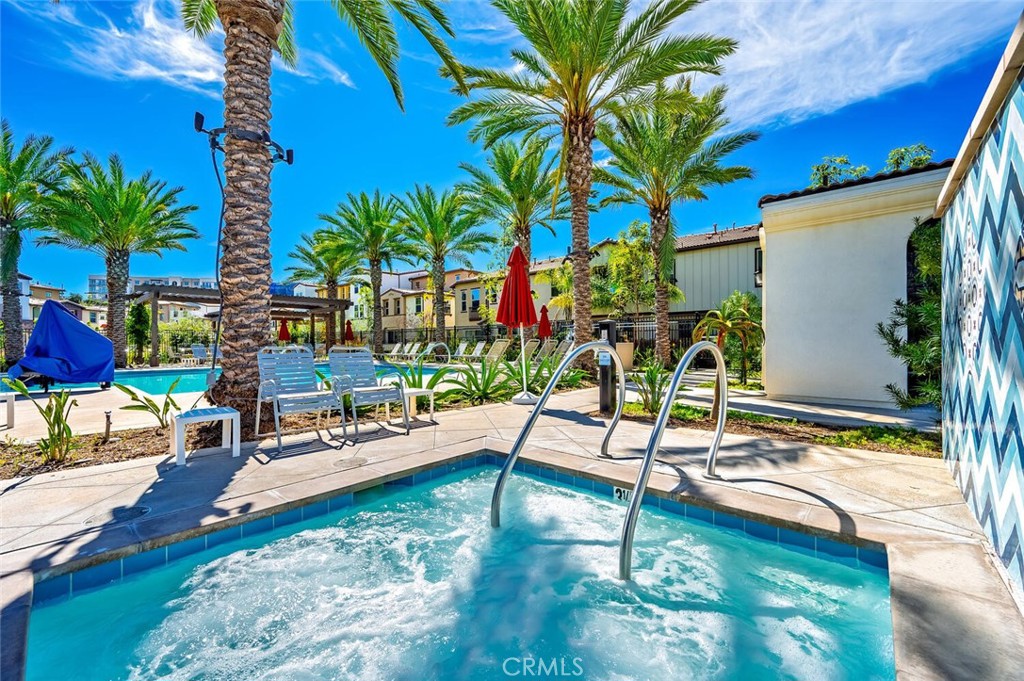 a view of a swimming pool with chairs and table in a patio