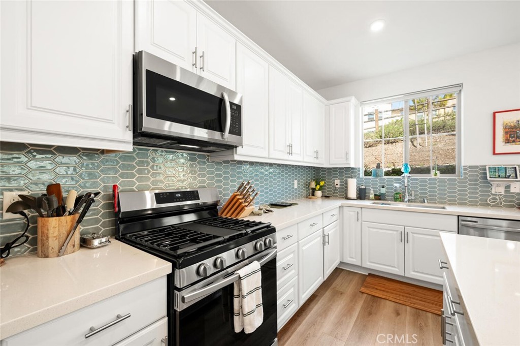 1852 Red Willow Way Oceanside, CA 92056 - Photo 13 of 52 a kitchen with stainless steel appliances a stove a microwave a sink and cabinets