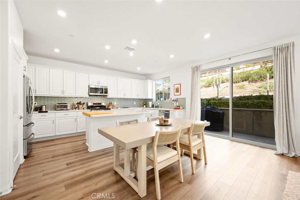 1852 Red Willow Way Oceanside, CA 92056 - Photo 8 of 52 a kitchen with white cabinets and stainless steel appliances