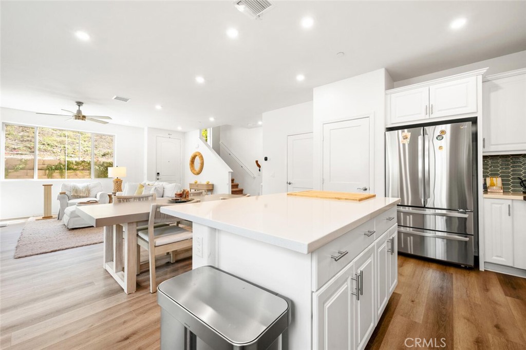 1852 Red Willow Way Oceanside, CA 92056 - Photo 10 of 52 a kitchen with a refrigerator a stove a sink and a dining table with wooden floor