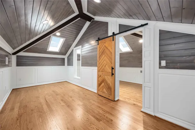 a view of an empty room with wooden floor and stairs