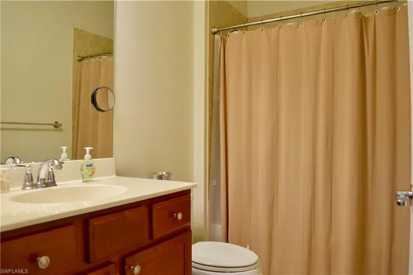a bathroom with a sink a toilet and shower curtain