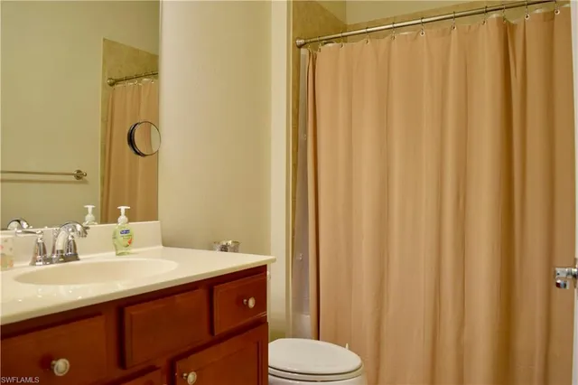 a bathroom with a sink a toilet and shower curtain