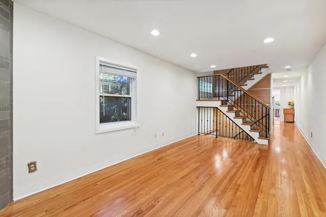 a view of a hallway with wooden floor and stairs
