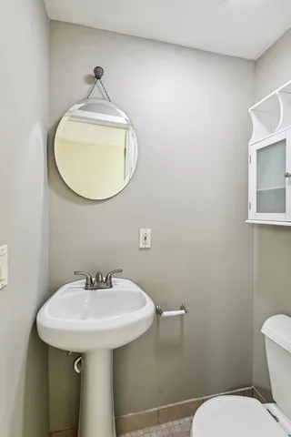 a bathroom with a sink a toilet and mirror