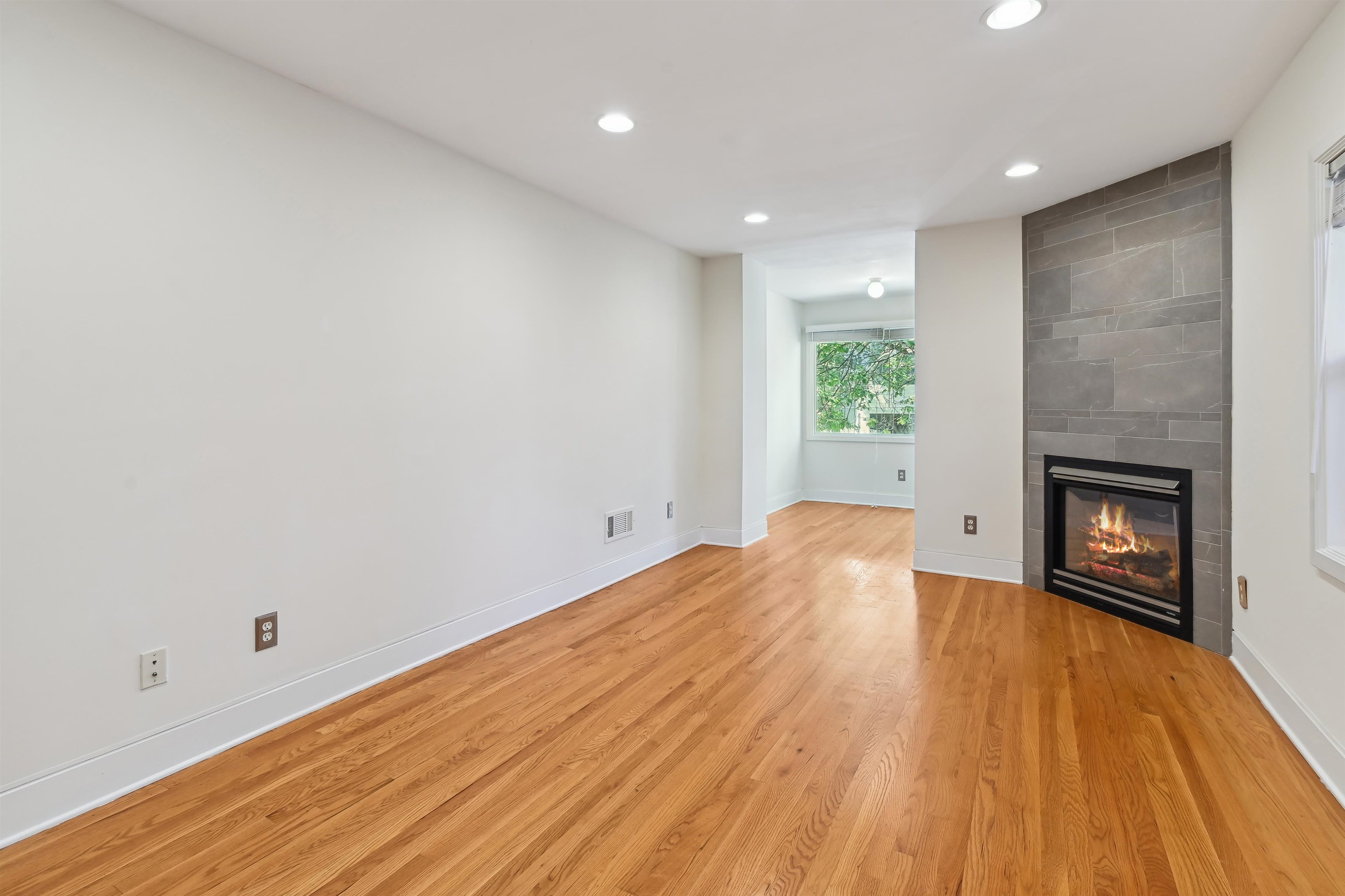 8 Carroll Place Weehawken, NJ 07086 - Photo 3 of 21 a view of empty room with wooden floor and fireplace