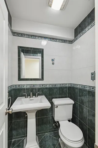 a bathroom with a toilet a sink and mirror