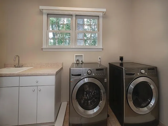 a utility room with sink dryer and washer