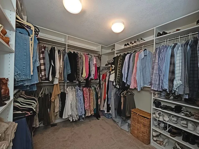 a view of walk in closet with clothes