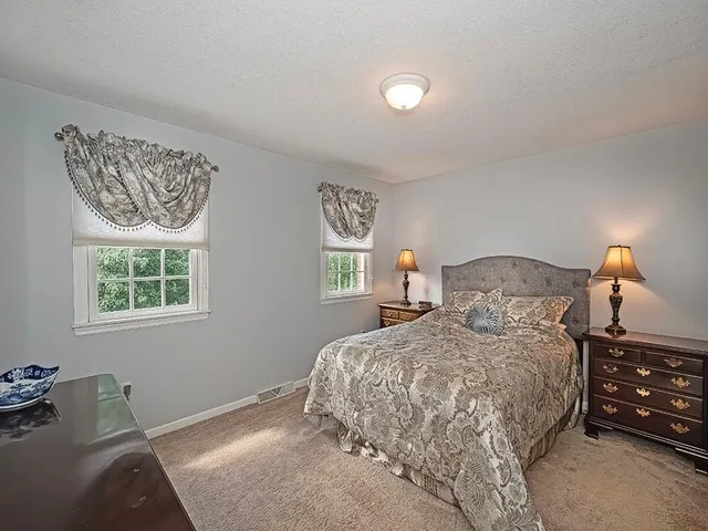 a bedroom with a bed a mirror and paintings on the wall