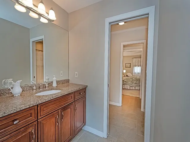 a bathroom with a granite countertop sink and a mirror