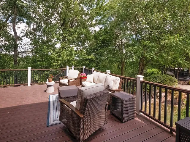a view of deck and deck with furniture and trees around