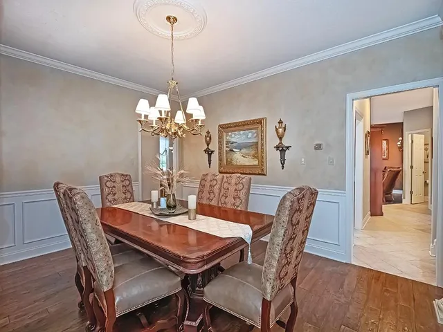 a dining room with furniture a chandelier and wooden floor