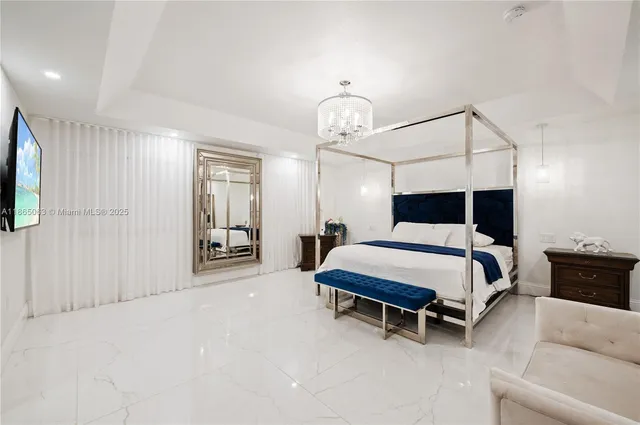 a bedroom with bed and a chandelier