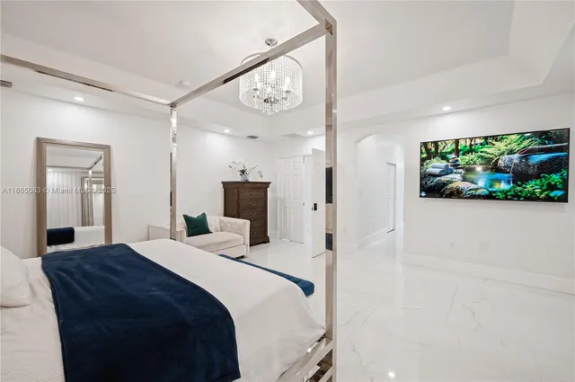 a large bedroom with a bed and a flat screen tv