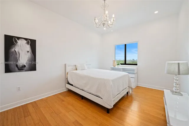 a bedroom with a large bed and a chandelier