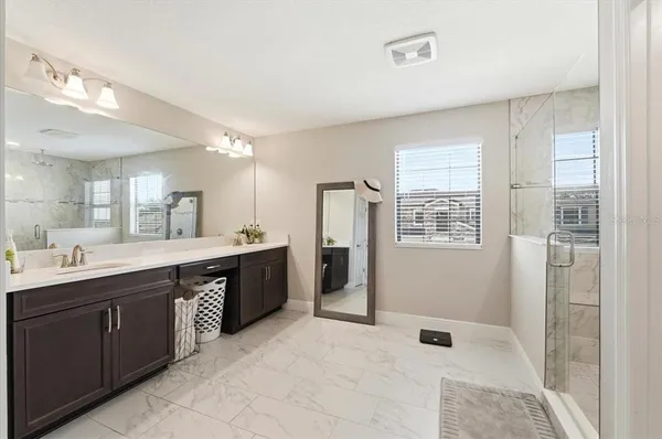 a large bathroom with a double vanity sink a large mirror and a bathtub