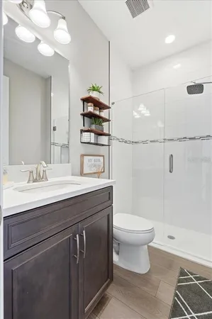 a bathroom with a sink a toilet and shower