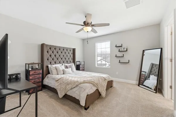 a bedroom with a bed a chair and a chandelier