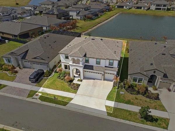 an aerial view of a house with a garden and large trees