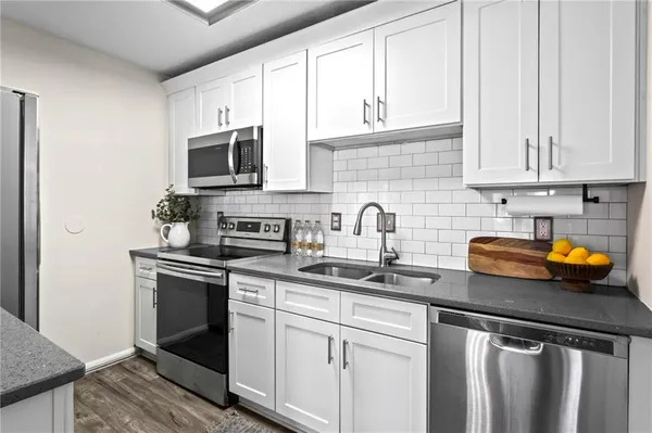a kitchen with stainless steel appliances granite countertop a sink stove and microwave