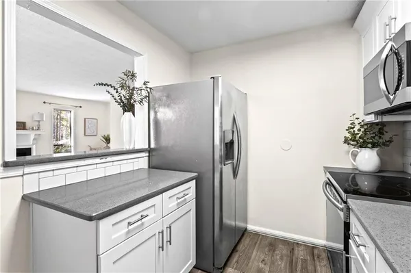 a kitchen with stainless steel appliances granite countertop a sink and a refrigerator