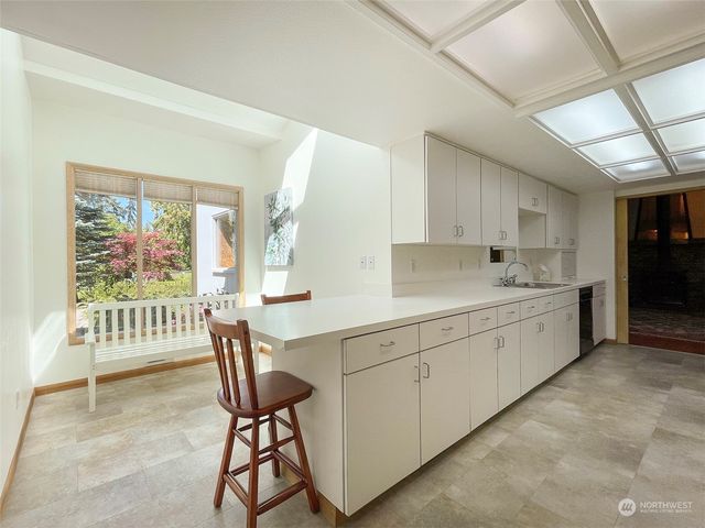 a large white kitchen with cabinets and a wooden floor