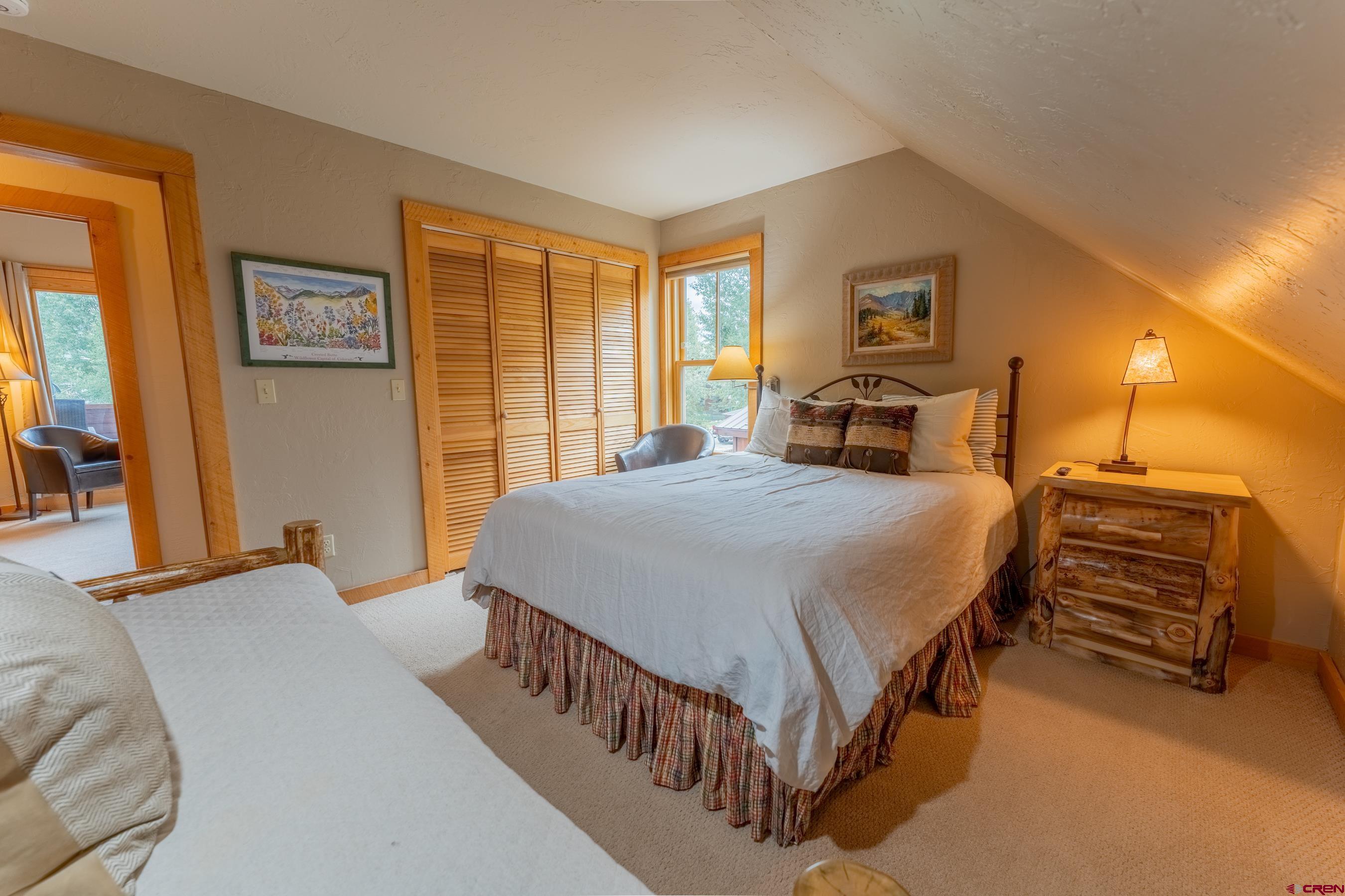 13 7th Street Crested Butte, CO 81224 - Photo 17 of 35 a spacious bedroom with a bed and dresser with mirror