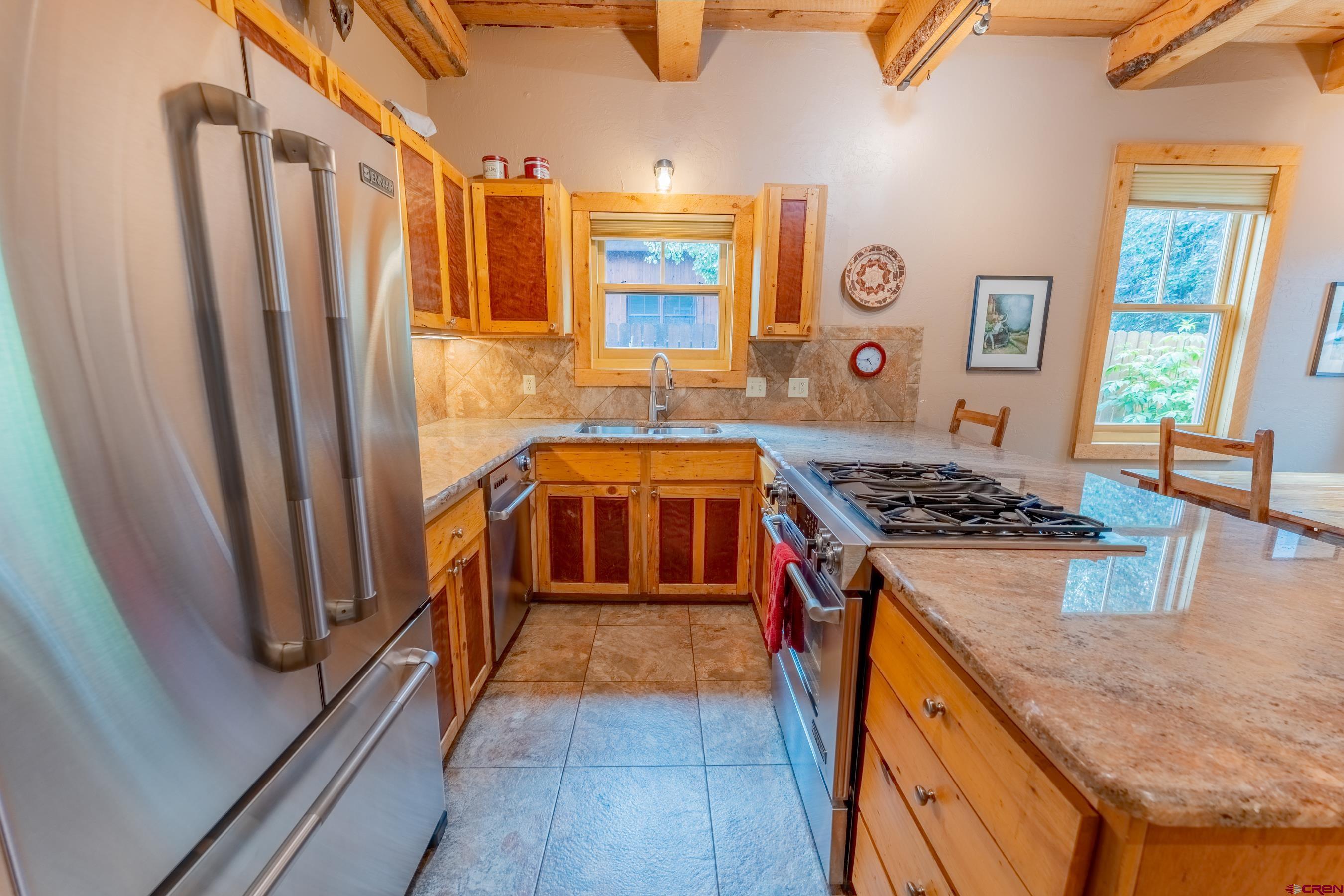 13 7th Street Crested Butte, CO 81224 - Photo 8 of 35 a kitchen with stainless steel appliances granite countertop a stove a sink and a refrigerator