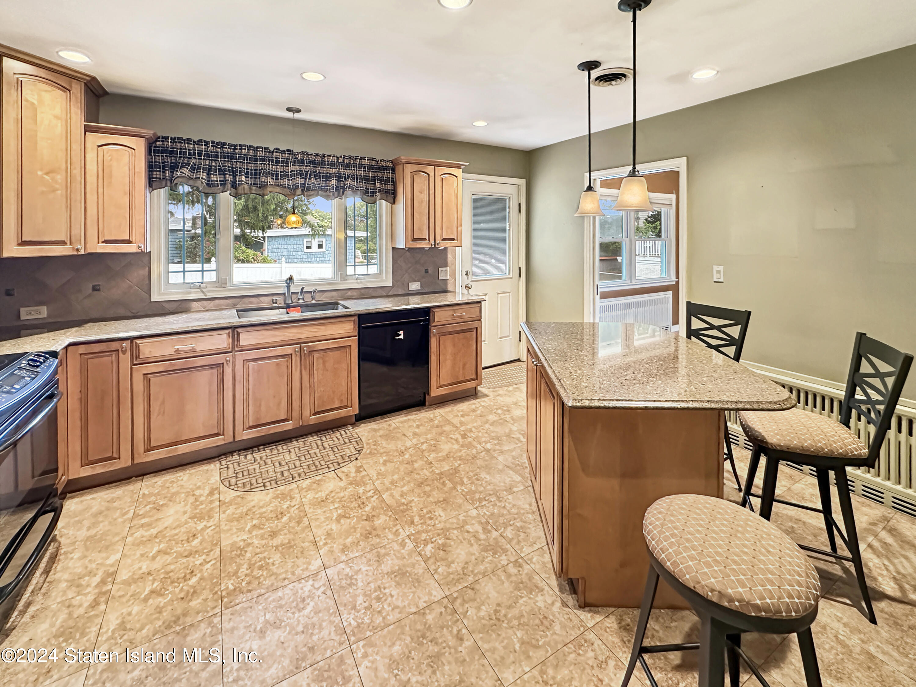 1085 Todt Hill Road Staten Island, NY 10304 - Photo 4 of 14 a kitchen with a table chairs sink and wooden floor